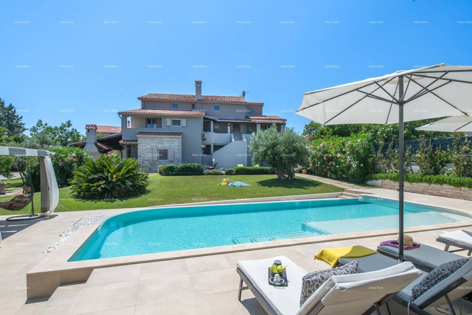 Entspannungsbereich am Pool mit Liegestühlen und Sonnenschirmen vor dem Wohnhaus.