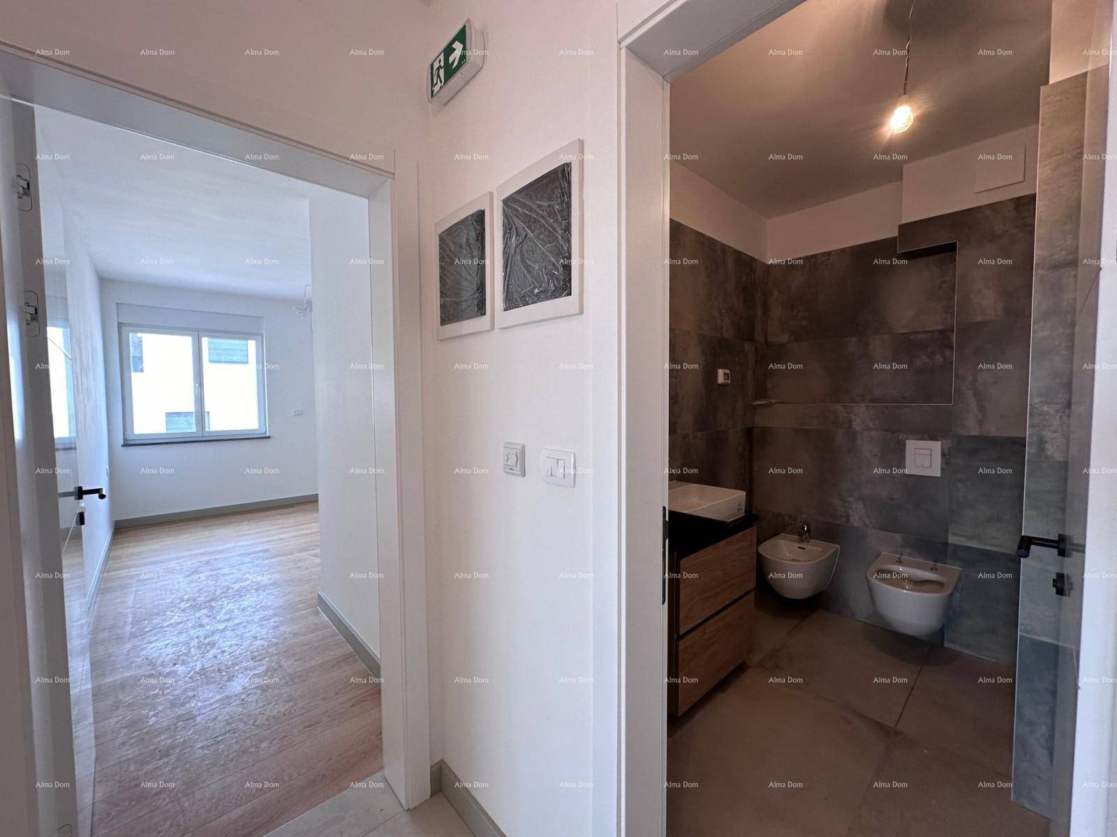 Flur mit Blick in ein modernes Badezimmer mit dunklen Fliesen und ein weiteres Zimmer.