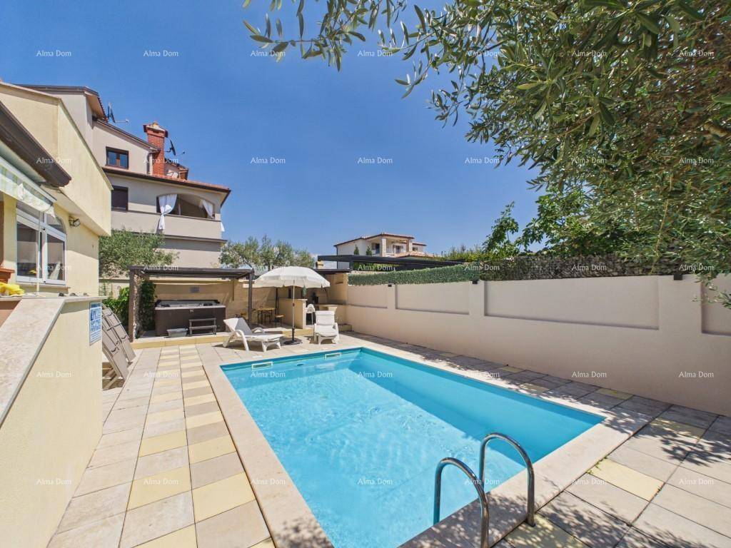 Außenbereich mit privatem Swimmingpool, Sonnenliegen und einem Whirlpool unter einer Pergola an einem sonnigen Tag.