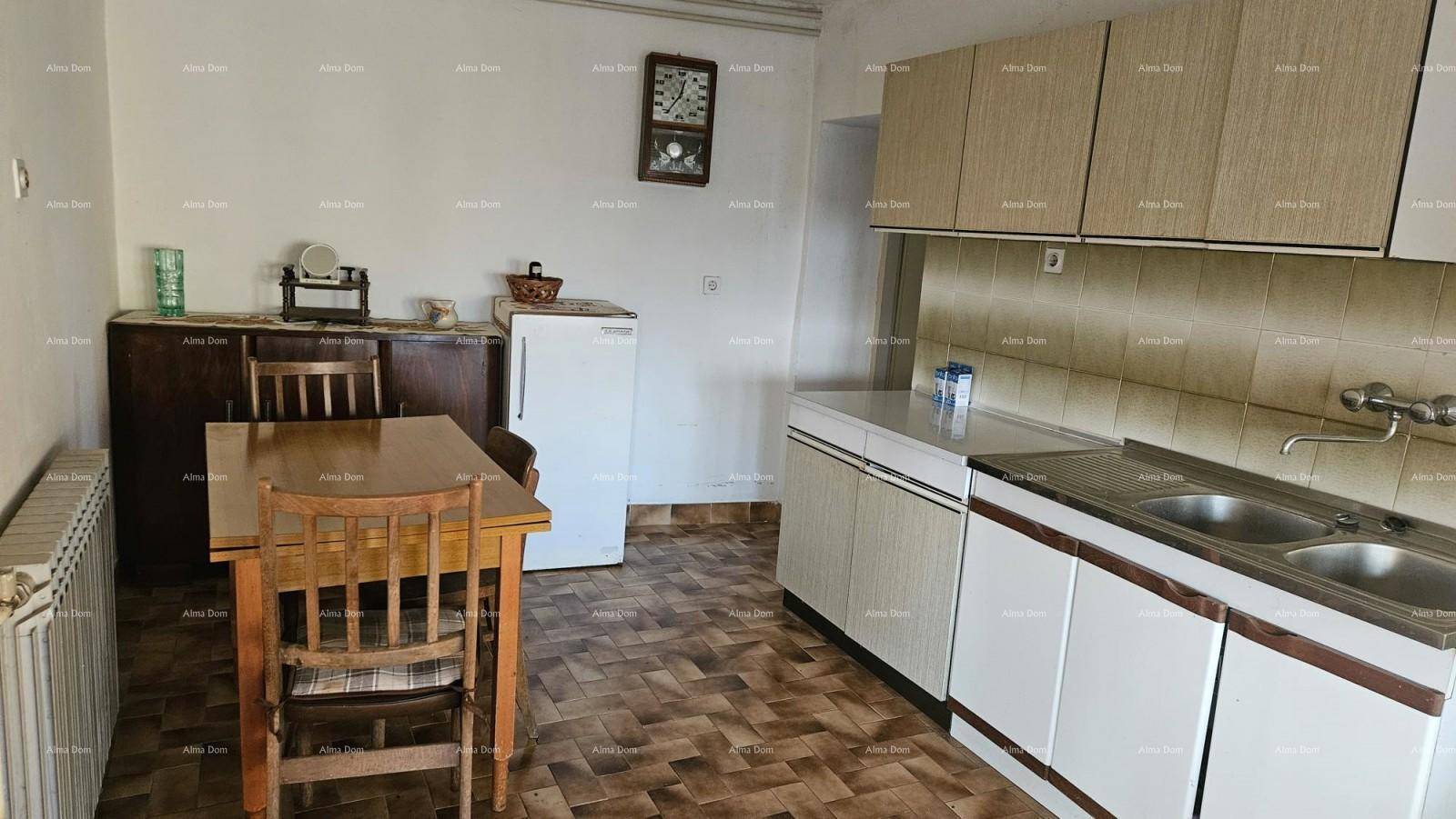Funktionale Küche mit Einbauschränken, Spüle, Kühlschrank und einem Esstisch für die Familie.