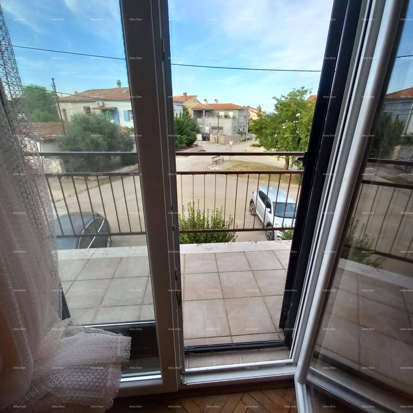 Blick aus einem Zimmer durch eine offene Balkontür auf die Straße und die umliegende Wohngegend.