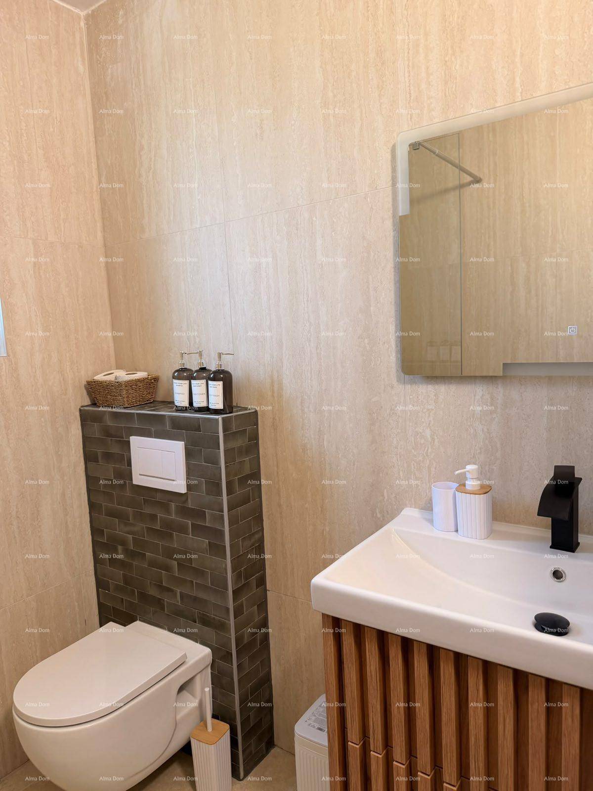 Badezimmer mit modernem Waschtisch, wandhängendem WC und Spiegel über dem Waschbecken.