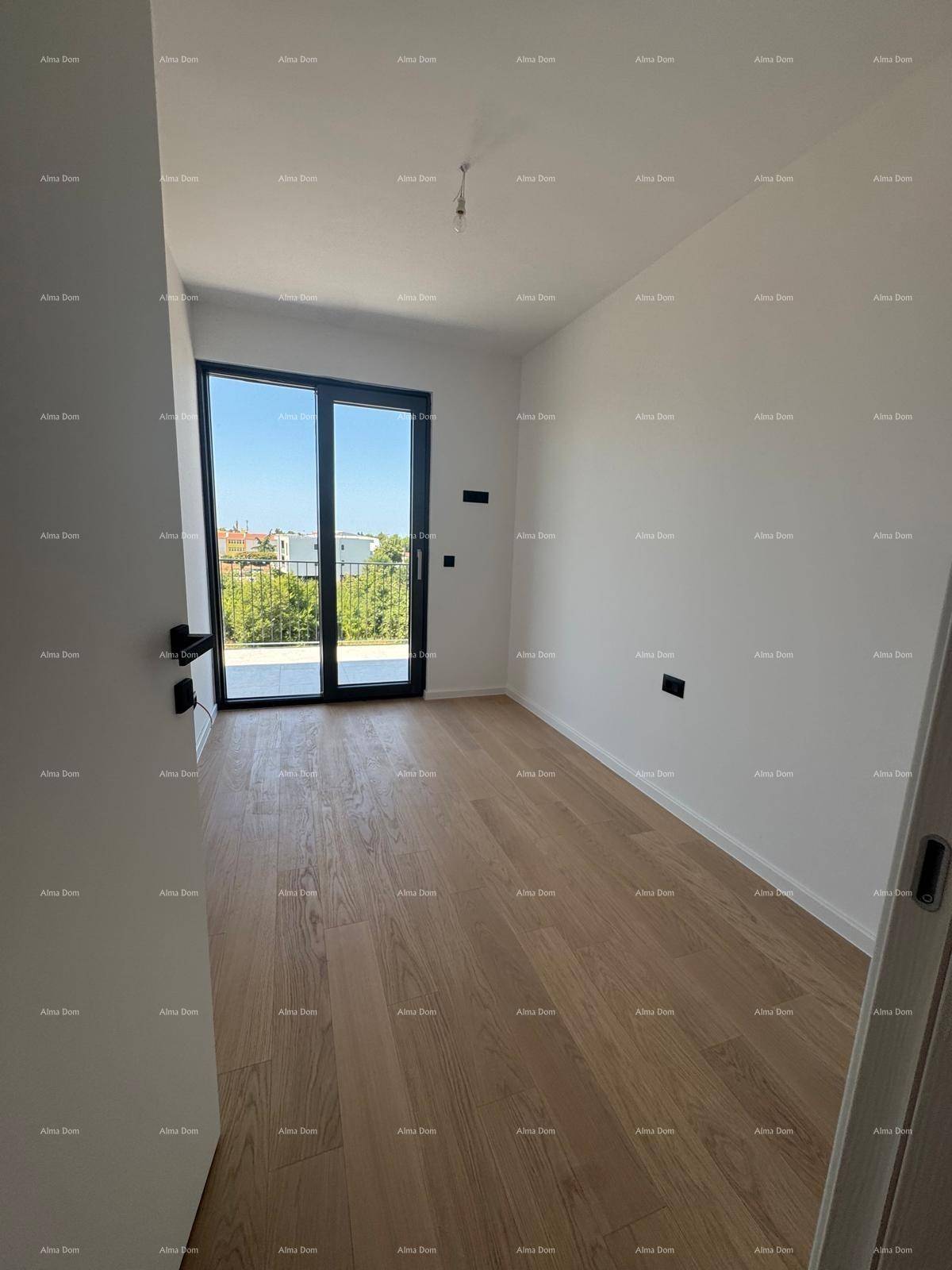 Leeres Schlafzimmer mit Holzboden und großer Glasschiebetür, die zu einem Außenbereich führt.