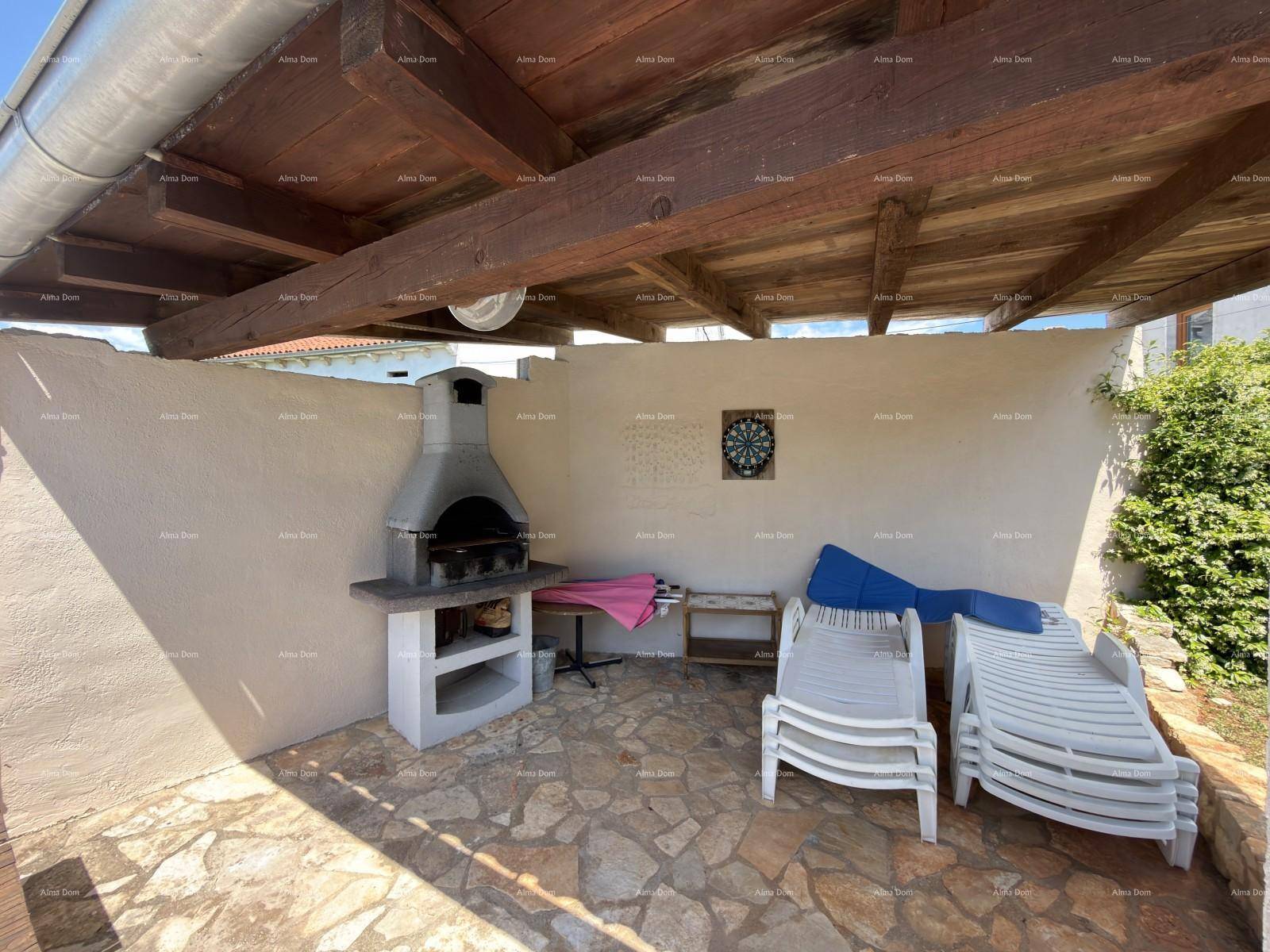 Überdachte Außenterrasse mit Grillbereich und Liegestühlen, ideal für entspannte Stunden im Freien.