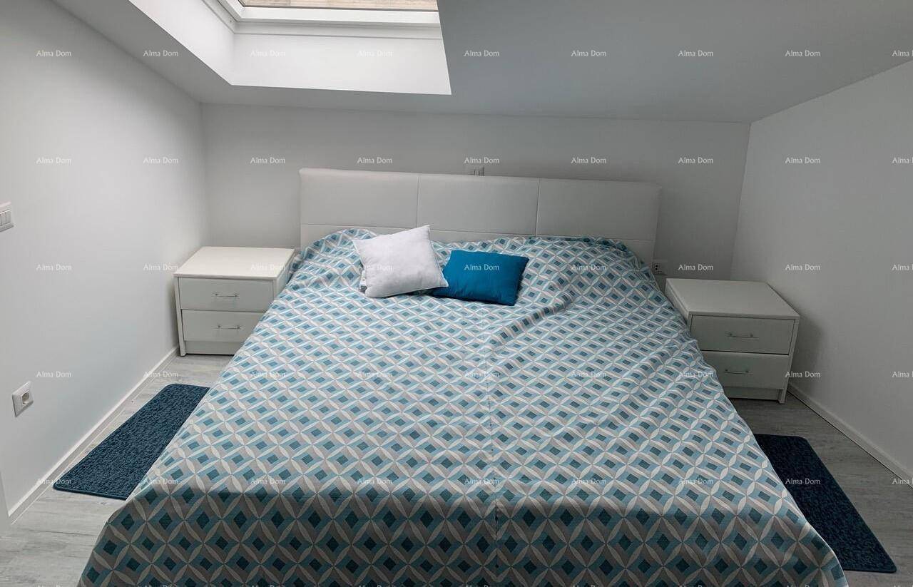 Gemütliches Schlafzimmer im Dachgeschoss mit Doppelbett, Nachttischen und einem Dachfenster.