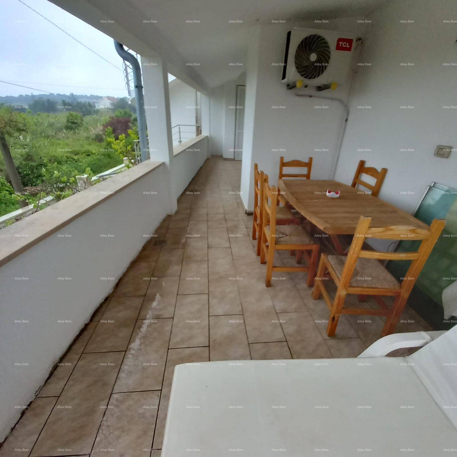Geräumiger Balkon mit Fliesenboden, Esstisch und Stühlen, umgeben von grüner Landschaft.