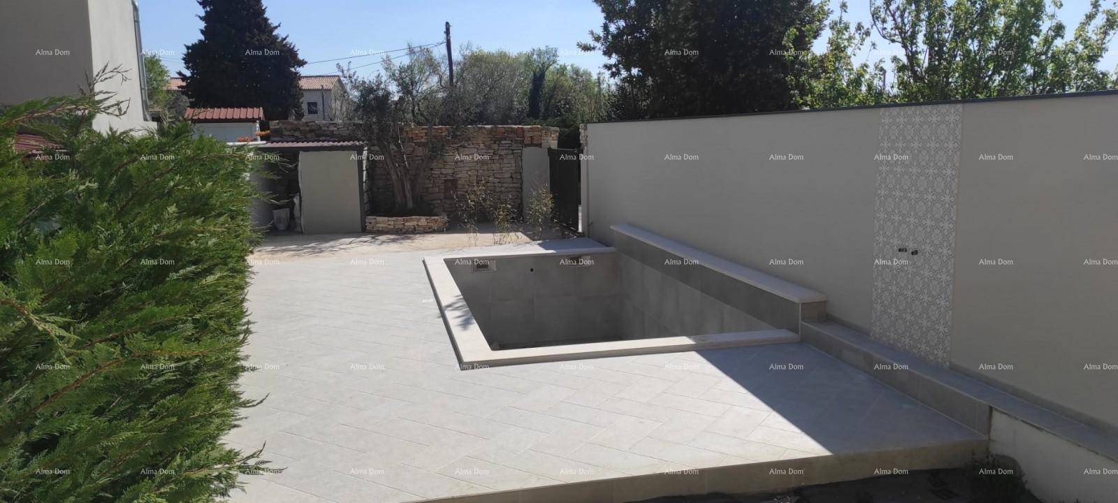 Außenbereich mit gefliester Terrasse und einem im Bau befindlichen Pool, umgeben von einer dekorativen Mauer.
