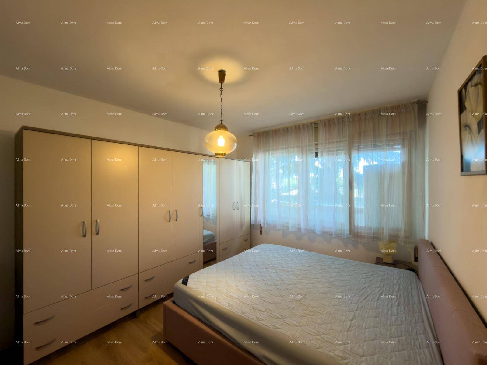Schlafzimmer mit großem Kleiderschrank, Doppelbett und Holzfußboden.