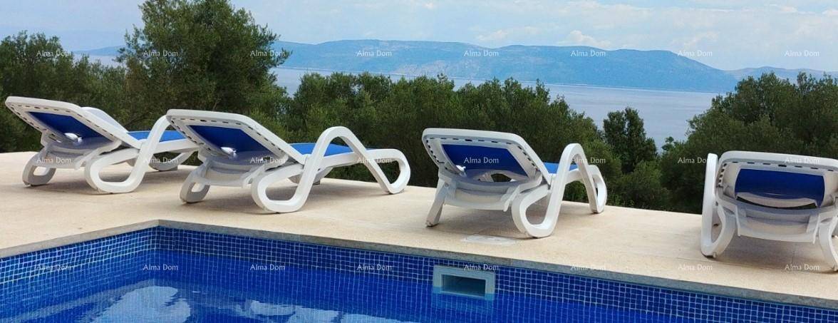 Entspannender Poolbereich mit Liegestühlen und Panoramablick auf das Meer und die Berge.