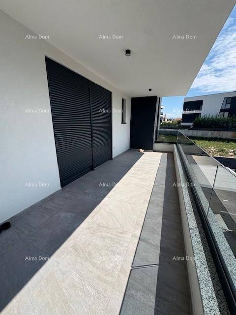 Langer Balkon mit Fliesenboden, Glasgeländer und Blick auf die Umgebung.