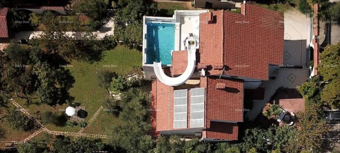Luftaufnahme des Anwesens mit rotem Ziegeldach, Swimmingpool, Wasserrutsche und großem grünen Garten.