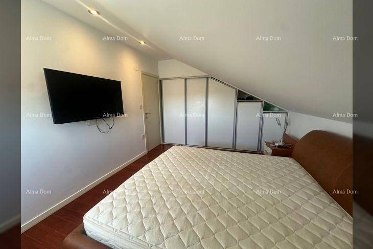 Schlafzimmer im Dachgeschoss mit Doppelbett, Einbauschränken und Wandfernseher.
