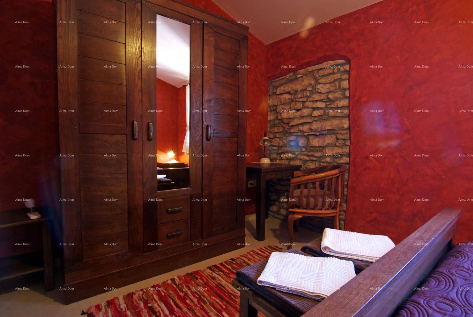 Schlafzimmer mit roten Wänden, großem Holzschrank mit Spiegel und einem bequemen Bett.