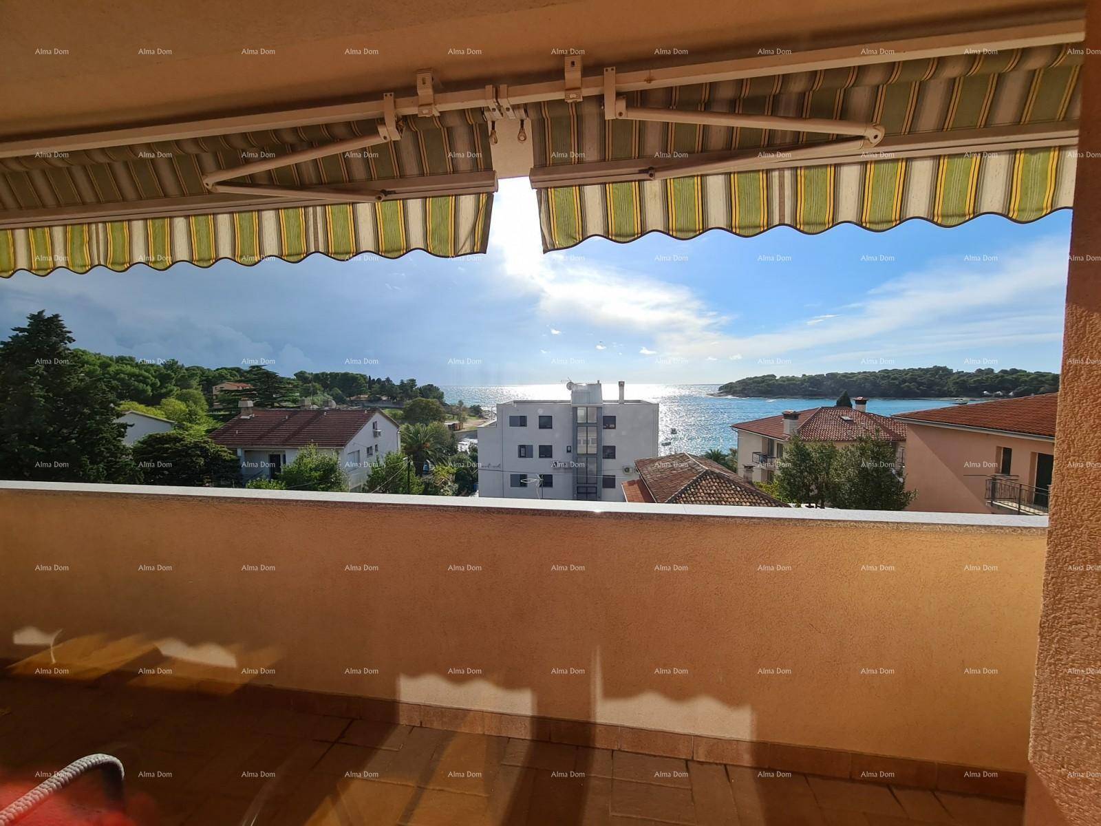Balkon mit Markise und weitem Blick auf das Meer und die Küstenlandschaft.