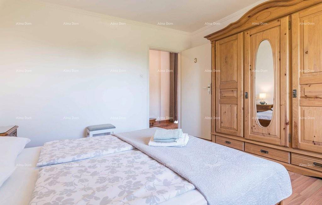 Schlafzimmer mit Holzboden, Doppelbett und großem Holzschrank mit Spiegel.