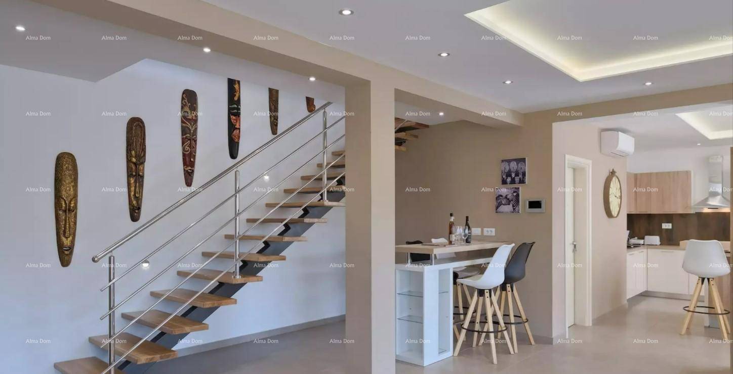 Heller Eingangsbereich mit Treppe, kleiner Bar und offenem Zugang zur modernen Küche.