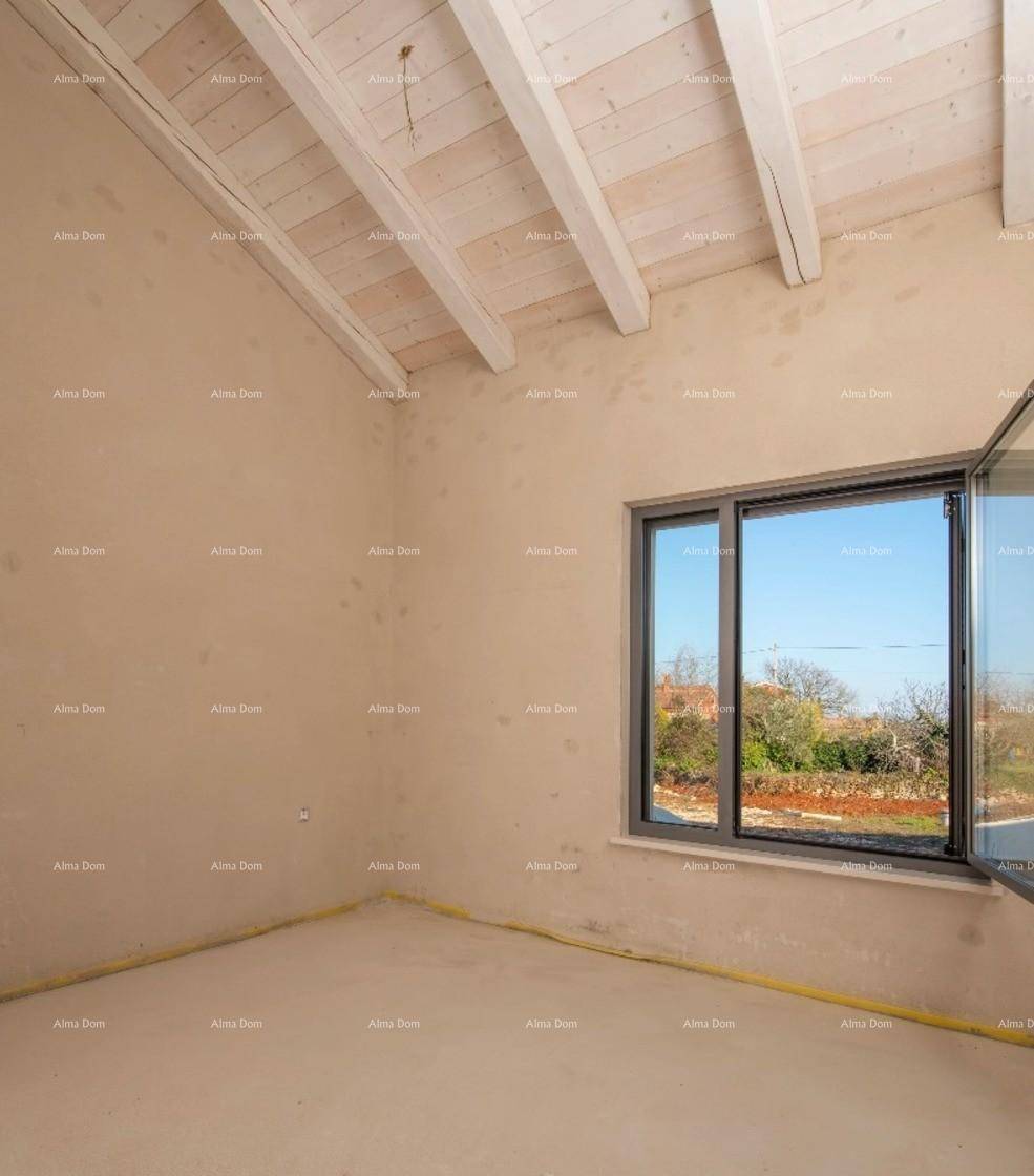 Raum im Rohbau mit großem Fenster und sichtbaren Deckenbalken, viel Tageslicht.