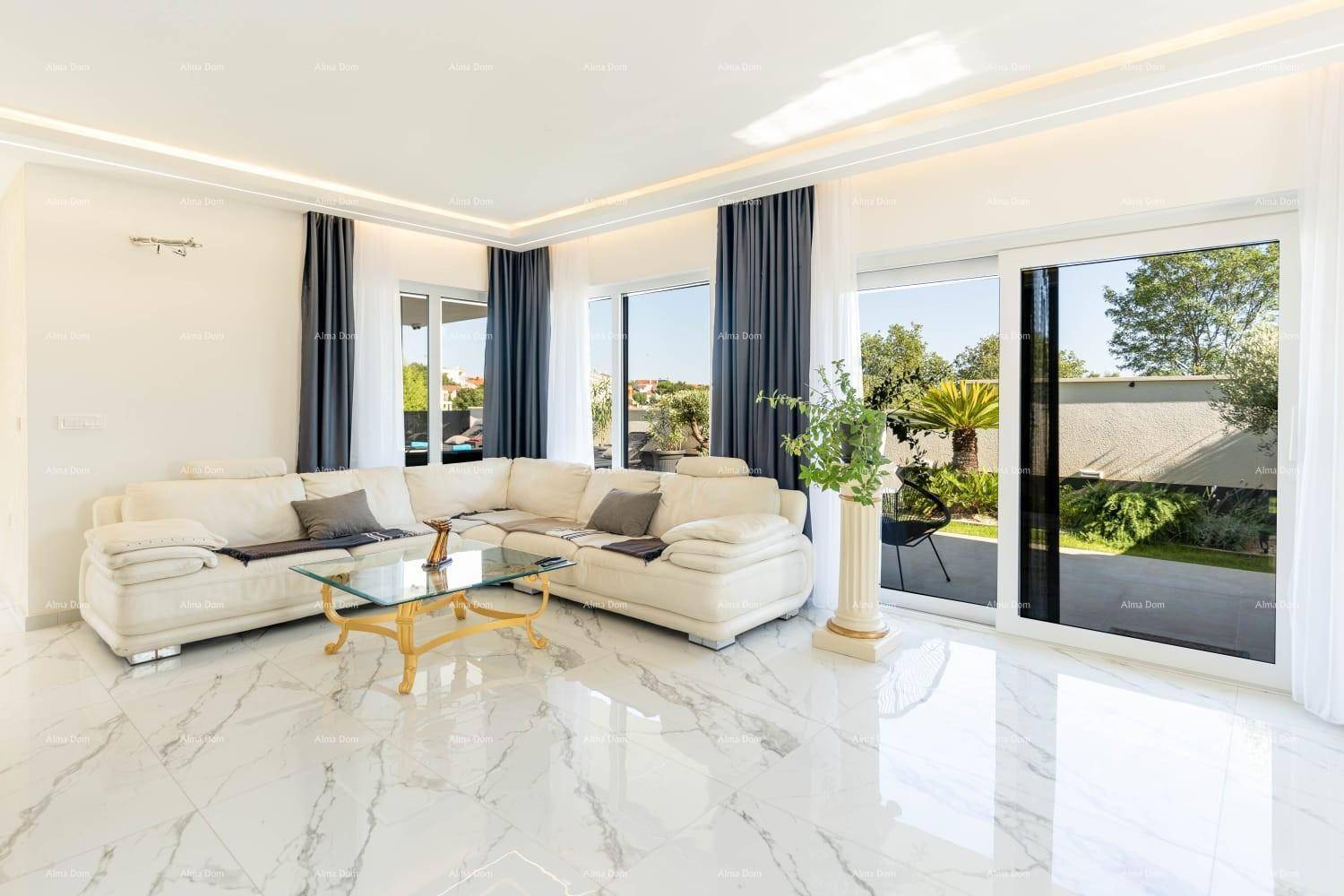 Geräumiges Wohnzimmer mit weißem Ecksofa, glänzenden Marmorfliesen und Zugang zum Außenbereich.