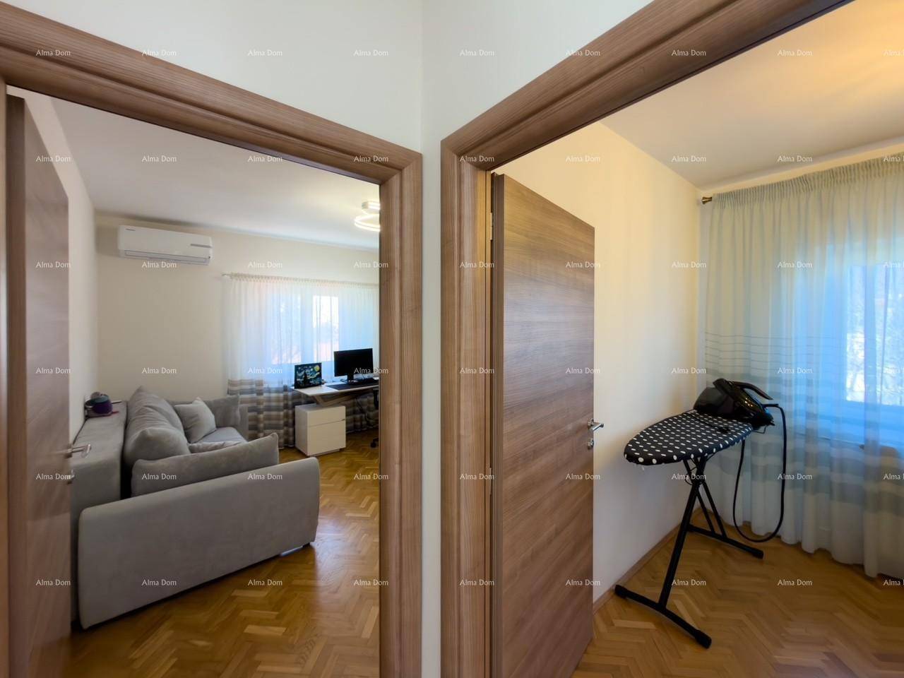 Flur mit Holztüren, der den Blick in ein Wohnzimmer und einen weiteren Raum freigibt.