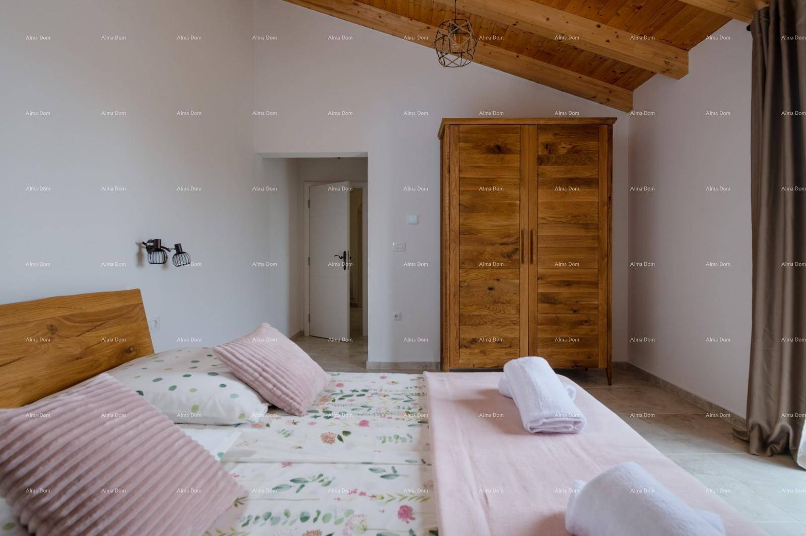Geräumiges Schlafzimmer mit Holzbett, Kleiderschrank und sichtbaren Holzbalken an der Decke.