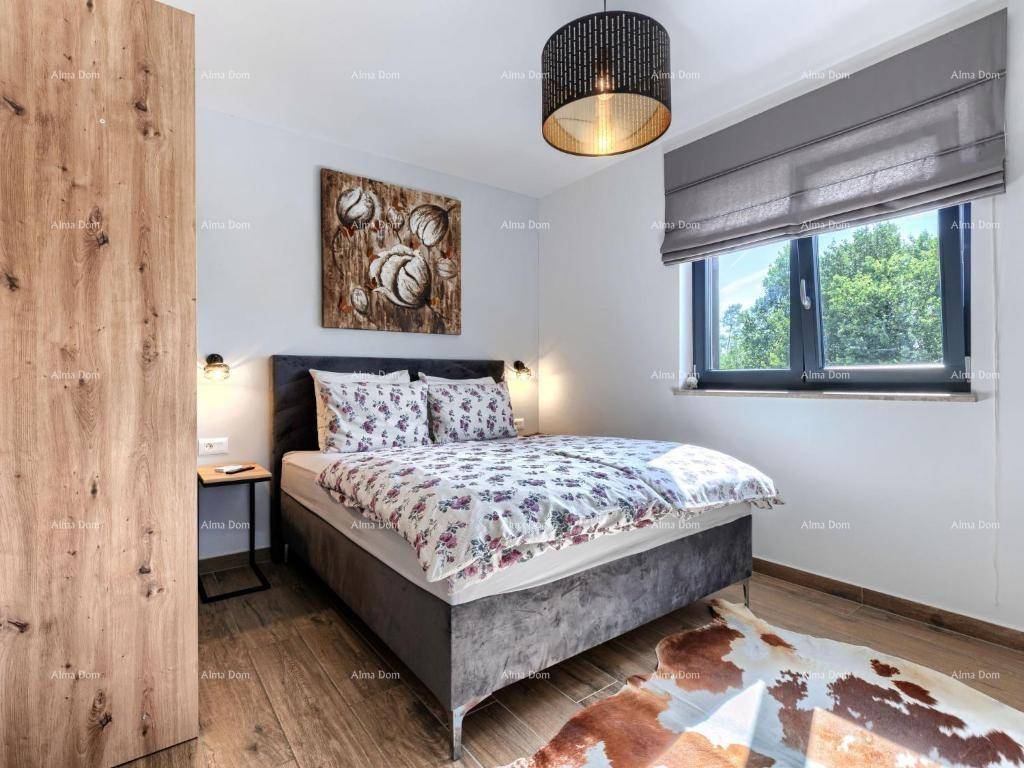Gemütliches Schlafzimmer mit Doppelbett, Holzkleiderschrank und Blick ins Grüne.