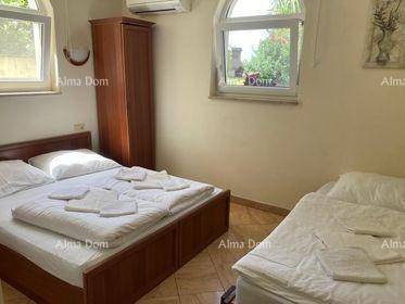 Schlafzimmer mit Doppelbett und Einzelbett, hellen Fenstern und Klimaanlage.