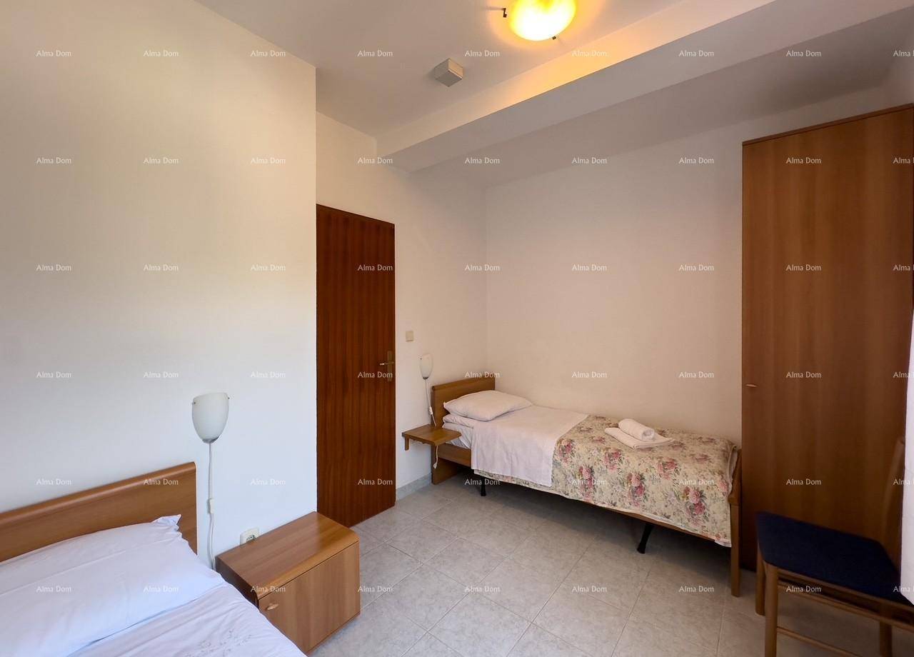 Schlafzimmer mit zwei Einzelbetten, Kleiderschrank und Nachttischen, funktional und hell eingerichtet.