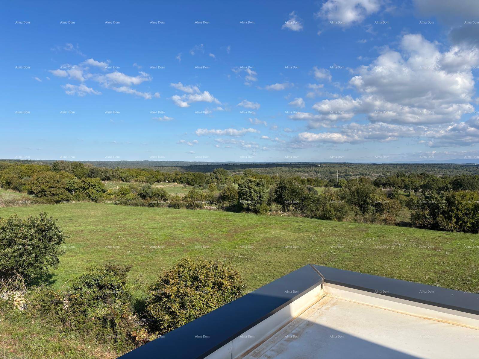 Weitläufiger Panoramablick über die grüne Landschaft und die Ferne unter einem bewölkten Himmel.