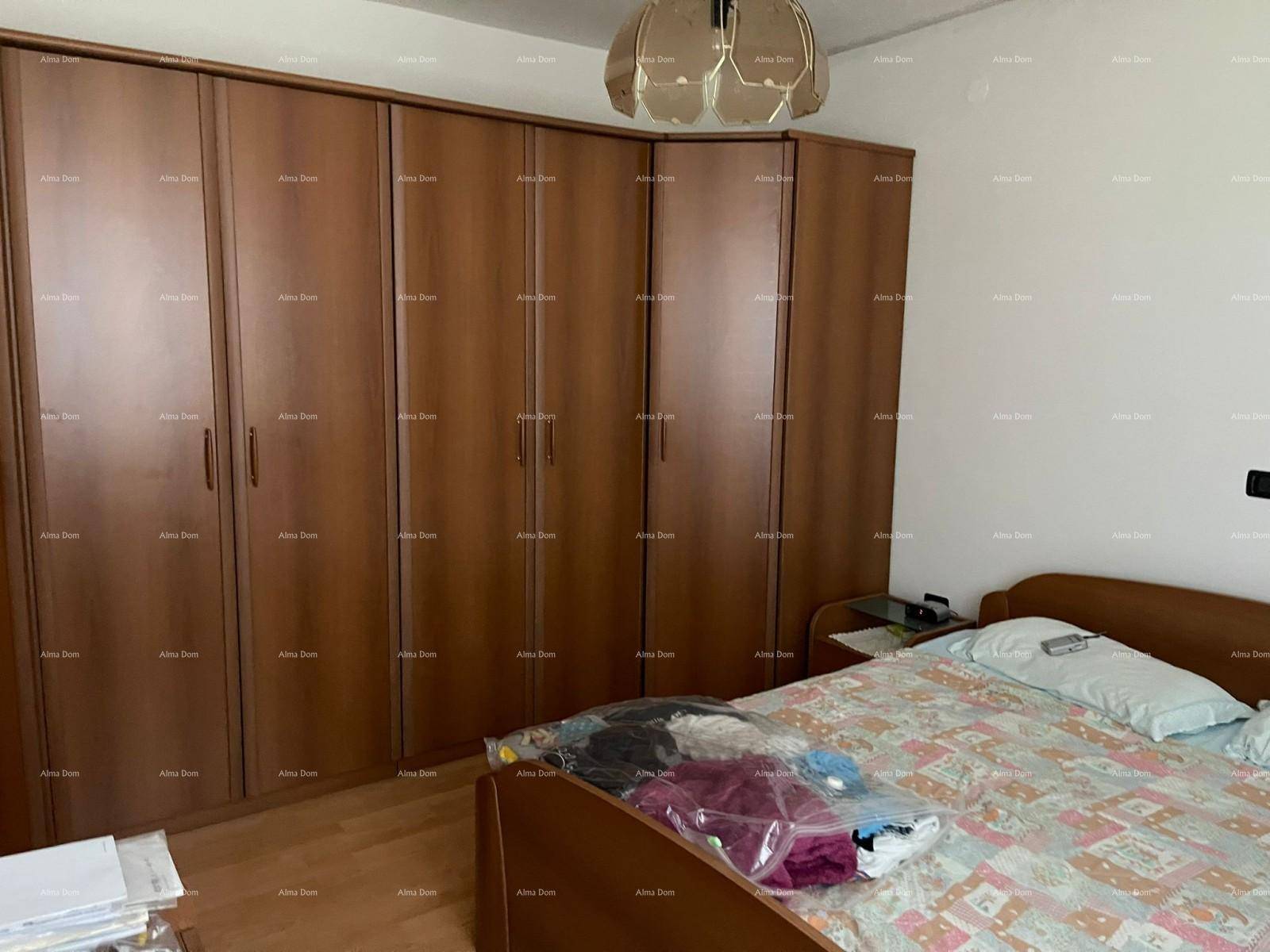 Schlafzimmer mit Doppelbett und einem geräumigen Holzschrank, der sich über die gesamte Wand erstreckt.