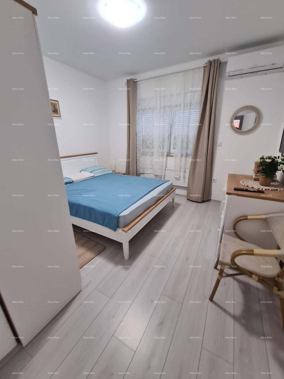 Geräumiges Schlafzimmer mit hellem Holzboden, großem Fenster und moderner Einrichtung.