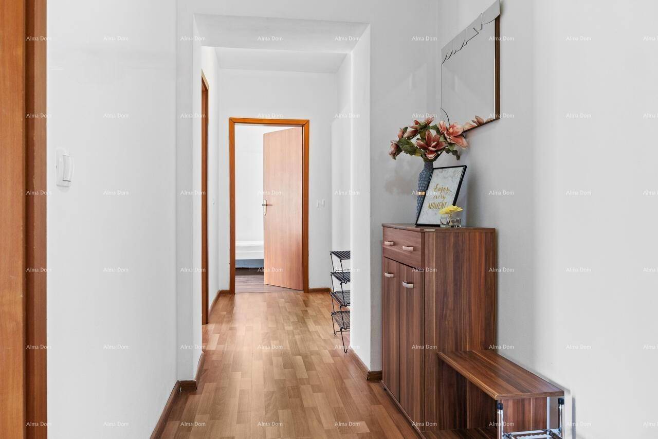 Geräumiger Flur mit Holzboden, Schuhschrank und dekorativen Blumenarrangements.