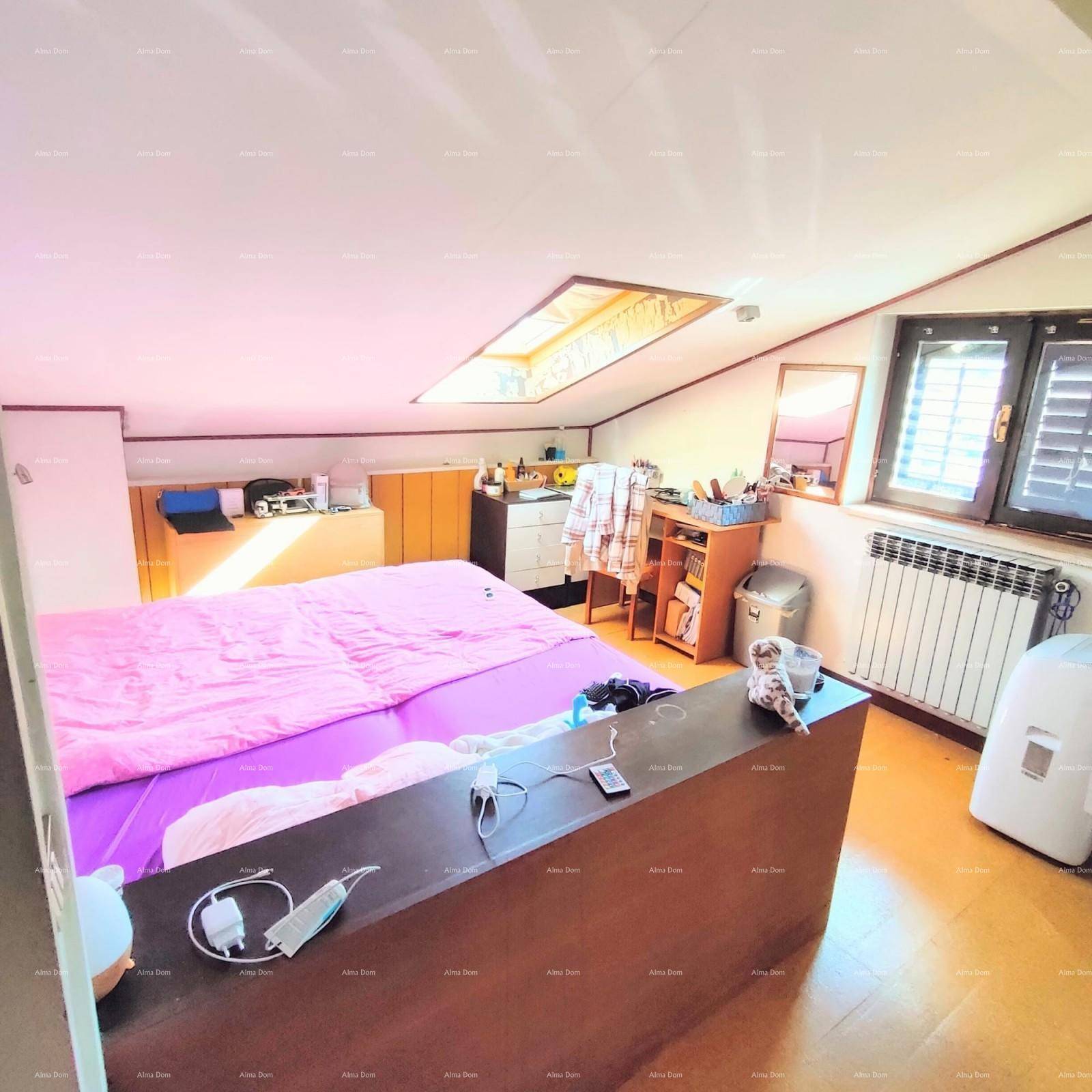 Geräumiges Dachschlafzimmer mit Holzboden, Dachfenster, Heizkörper und viel natürlichem Licht.