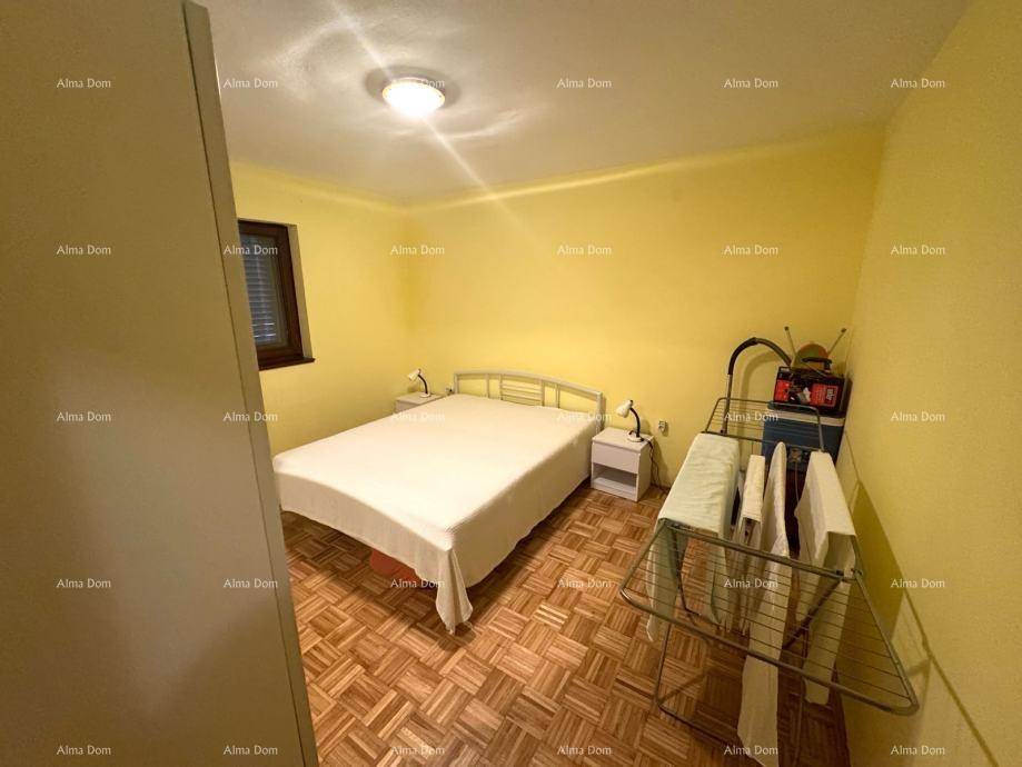 Schlafzimmer mit Parkettboden, Doppelbett, gelben Wänden und einfacher Einrichtung.