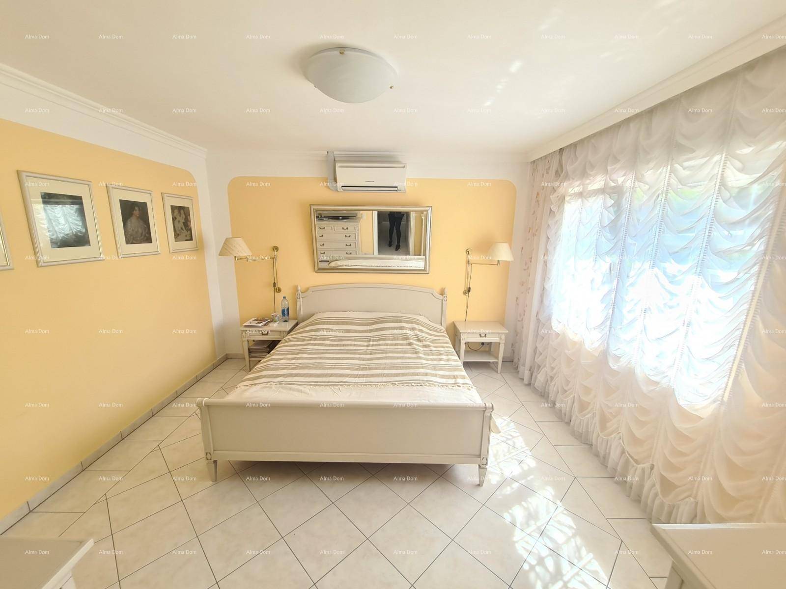 Helles Schlafzimmer mit Doppelbett, Klimaanlage und gelb gestrichener Wand.