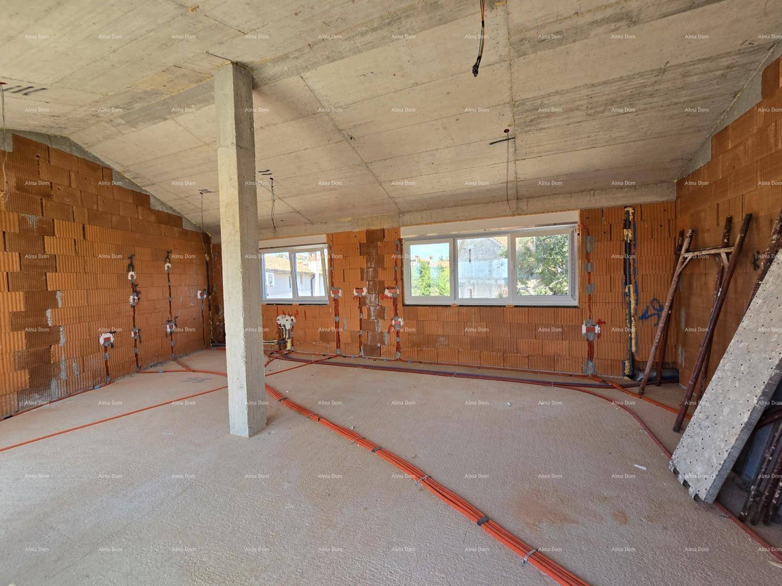 Großer Wohnraum im Rohbau mit Ziegelwänden, Betondecke und Dachschräge.