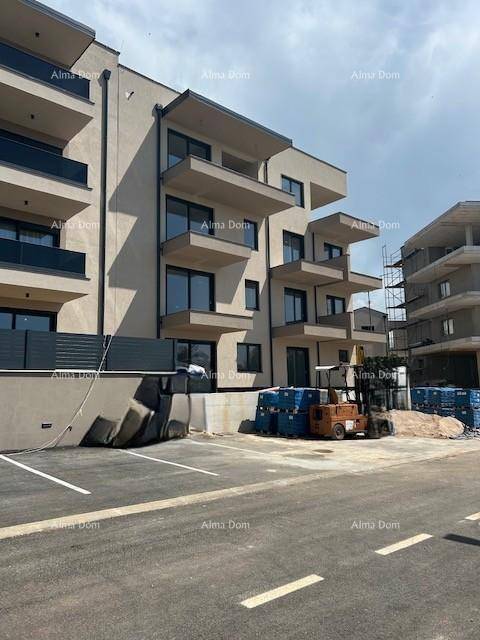 Neubau eines Wohngebäudes mit moderner Fassade und Baustellenbereich davor, teilweise mit Gerüst.