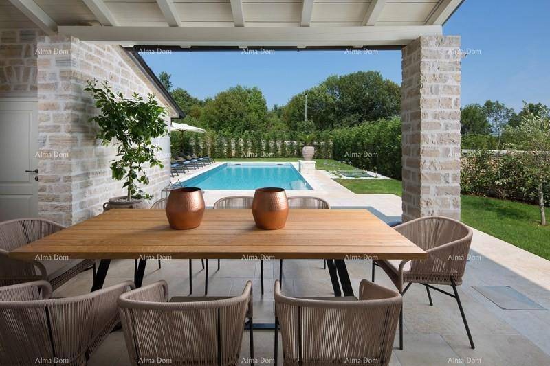 Überdachte Terrasse mit großem Esstisch und Blick auf den Pool und die grüne Umgebung.