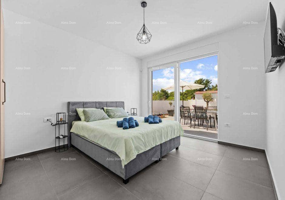 Helles Schlafzimmer mit Doppelbett, Fliesenboden und direktem Zugang zur Terrasse.