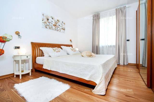 Helles Schlafzimmer mit Holzbett, Parkettboden und großem Fenster.