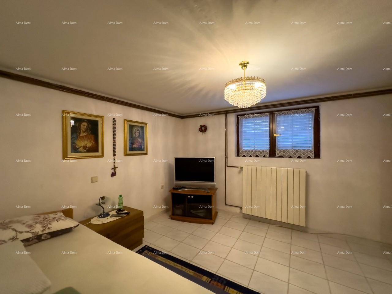 Schlafzimmer mit Doppelbett, Fernseher, gefliestem Boden und einem Fenster mit Jalousien.