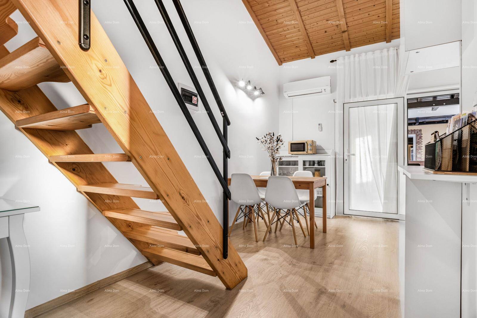 Heller Essbereich mit Holztreppe, Esstisch und Zugang zu einem Außenbereich.