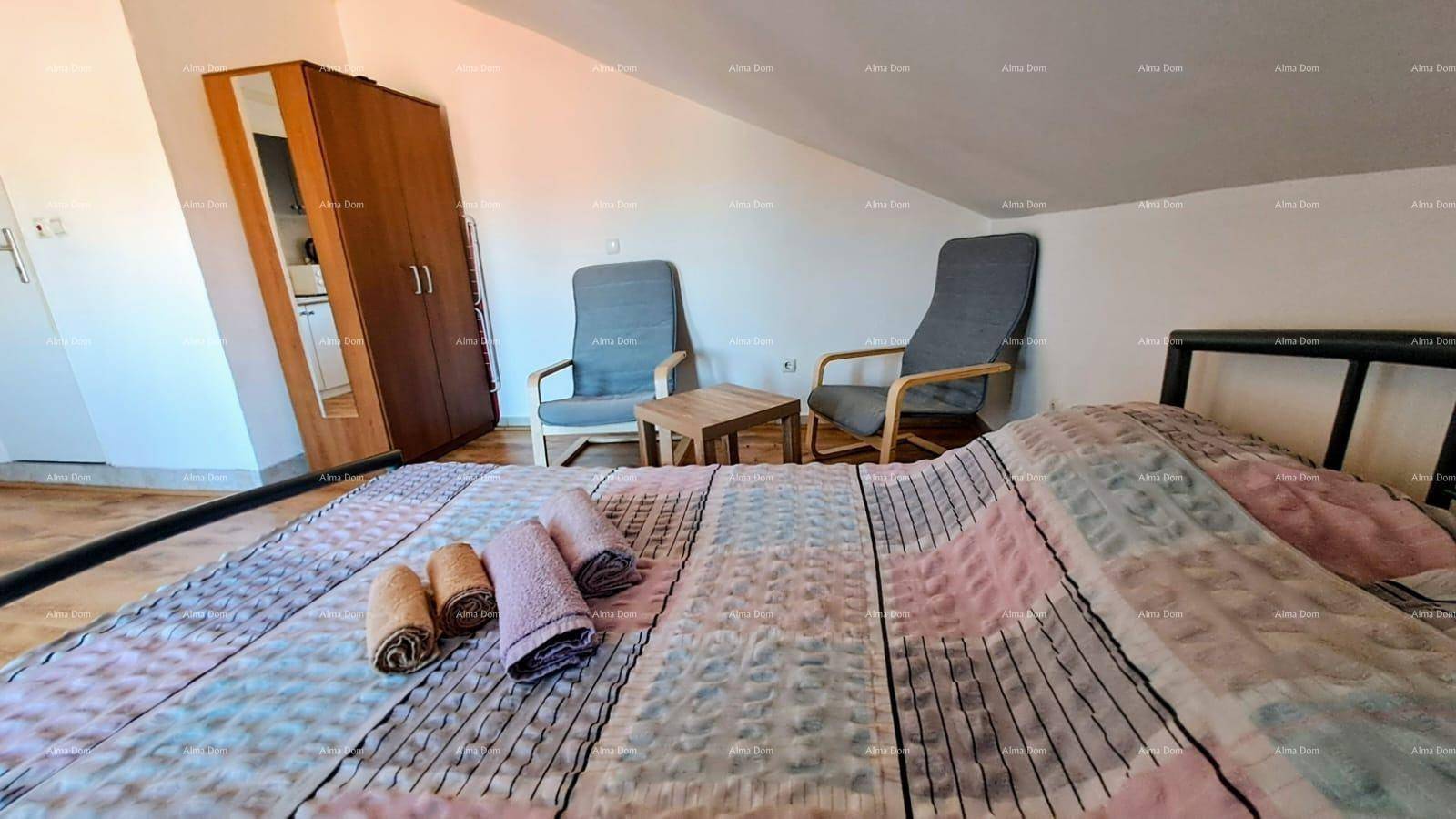 Gemütliches Schlafzimmer im Dachgeschoss mit Doppelbett, Sitzgelegenheiten und Kleiderschrank.