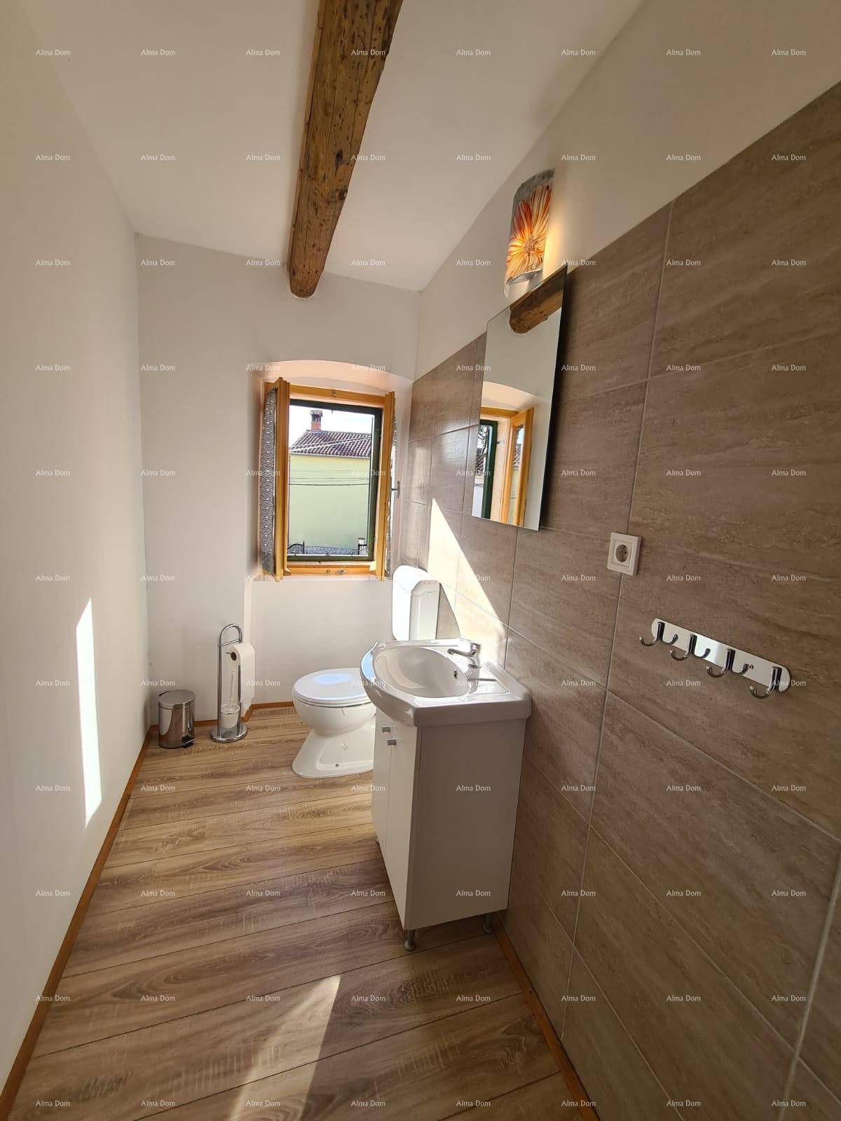 Helles Badezimmer mit Toilette, Waschbecken, Fenster und modernen Fliesen.