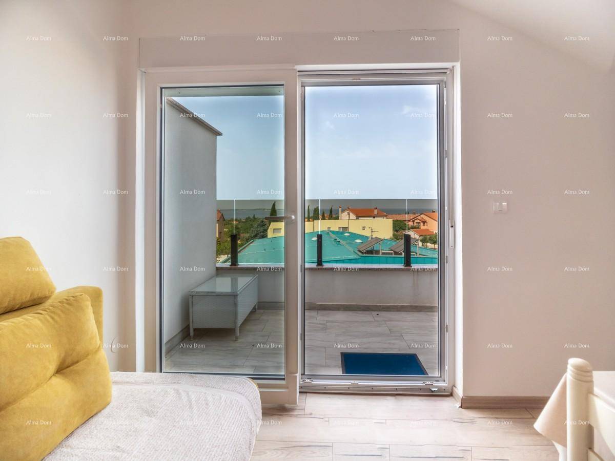 Wohnbereich mit großen Schiebetüren, die zu einer Terrasse mit Blick auf die Umgebung führen.