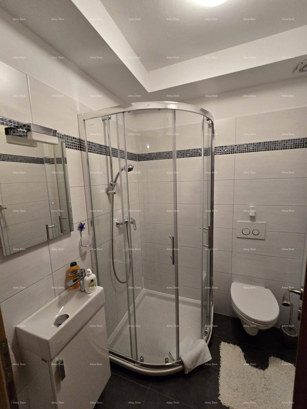 Modernes Badezimmer mit Duschkabine, wandhängendem WC und kleinem Waschbecken, hell gefliest.