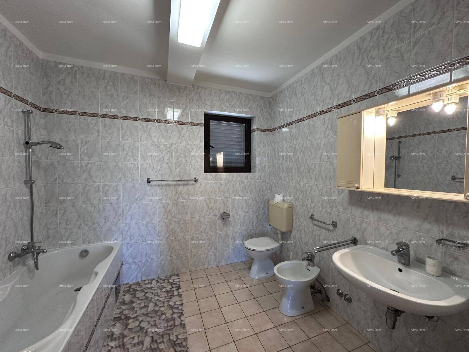 Funktionales Badezimmer mit Badewanne, Dusche, WC, Bidet und Waschbecken, komplett gefliest.