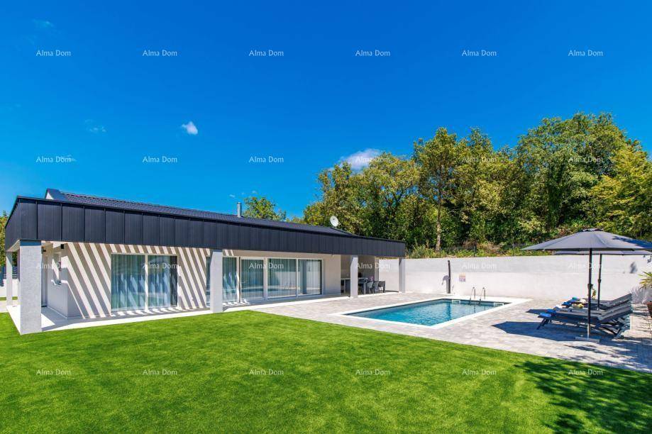 Moderne Villa mit großem Rasen, Swimmingpool und Liegebereich unter strahlend blauem Himmel.