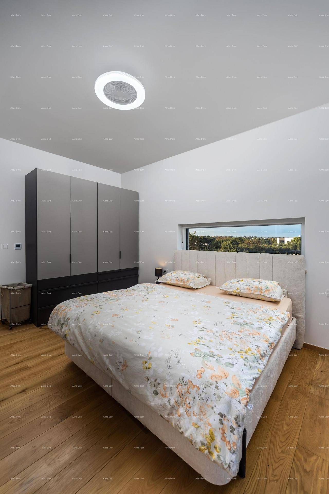 Schlafzimmer mit Doppelbett, modernem Kleiderschrank und Holzboden, gut beleuchtet.