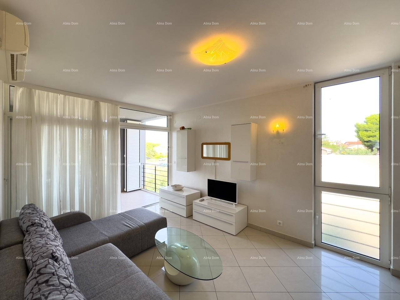 Helles Wohnzimmer mit großen Fenstern, die viel Tageslicht hereinlassen und Zugang zum Balkon bieten.