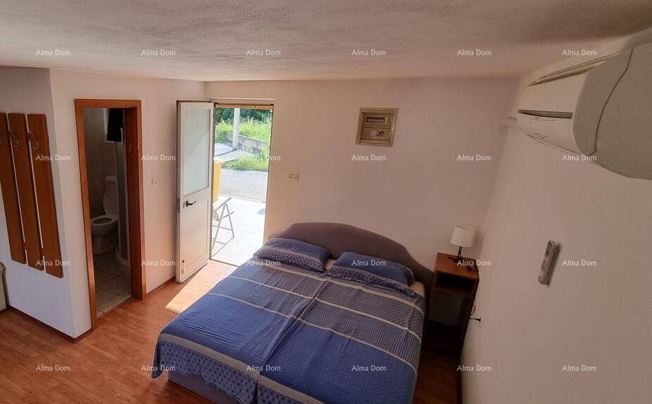 Helles Schlafzimmer mit Doppelbett, Klimaanlage und direktem Zugang zum Garten.